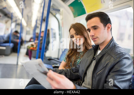 Paar auf Zug lesen Zeitung Stockfoto