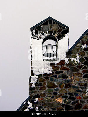 Das Bild zeigt die Kirche des Guten Hirten am Lake Tekapo im neuseeländischen Mackenzie Country. Vor dem Hintergrund der atemberaubenden Berglandschaft und des Sonnenuntergangs zeigt diese malerische Szene die berühmte Steinkirche, die natürliche Schönheit mit architektonischer Einfachheit verbindet. Stockfoto