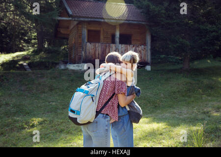 Zwei Freundinnen umarmen in Waldlichtung, Sattelbergalm, Tirol, Österreich Stockfoto