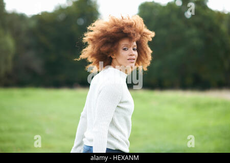 Porträt von geschweiften dunkelhaarige Frau über die Schulter in die Kamera schaut Stockfoto