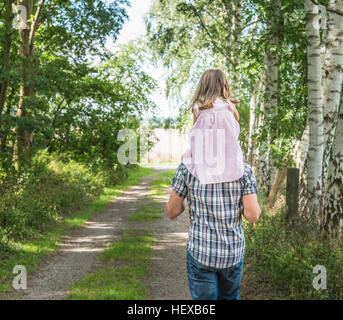 Rückansicht des Vater mit Tochter auf Schultern, Porta Westfalica, Nord Rhein Westfalen, Deutschland Stockfoto