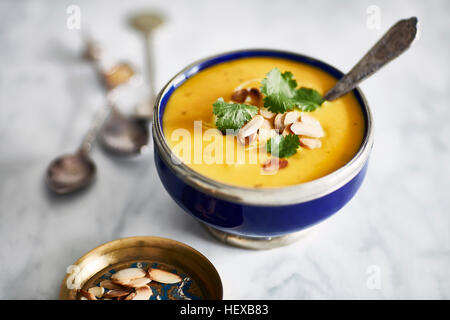 Butternut-Kürbis-Suppe, garniert mit gerösteten Mandeln und Petersilie Stockfoto