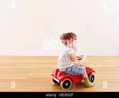 Kleine Mädchen spielen mit Tretauto Stockfoto