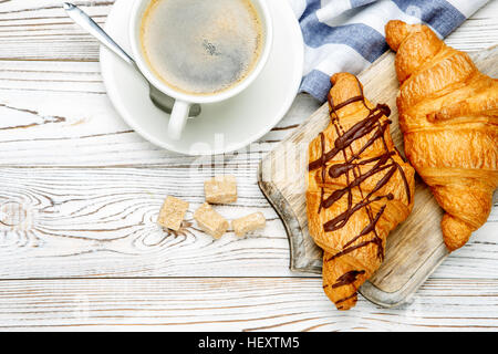 zwei frische Croissants und Kaffee auf hölzernen Hintergrund Stockfoto