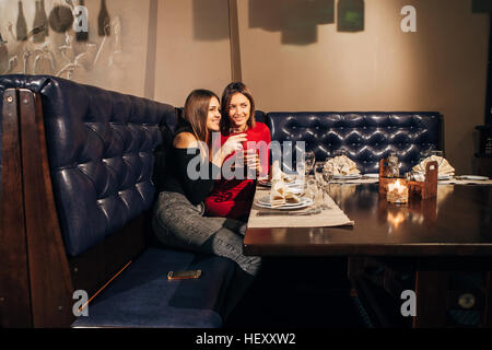 zwei schöne junge Frauen sah etwas im restaurant Stockfoto