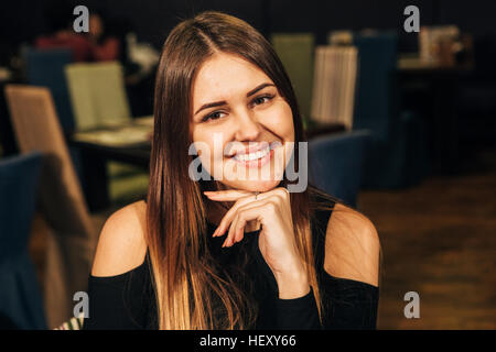 junge Brünette Frau im Restaurant lächelt Stockfoto
