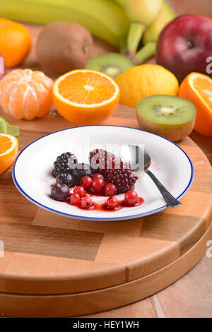 Beeren in weißen Teller und andere Früchte rund um Stockfoto