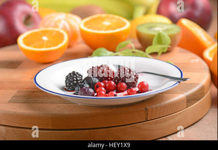 Beeren in weißen Teller und andere Früchte rund um Stockfoto