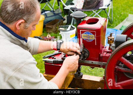 Ein Mann stellt eine Stationärmotor bei einer county Show. Stockfoto