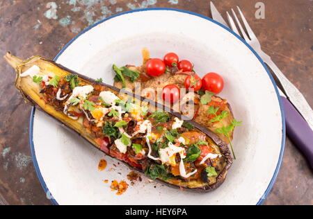 gefüllte Auberginen auf einer Platte mit Cherry-Tomaten und Hüttenkäse Stockfoto