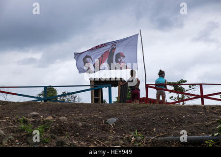 Kinder und eine Fahne mit Fidel und Raul Castro fliegen bei Yomuri, Baracoa, Schauplatz der Hilfsmaßnahmen, Hurrikan Mathew, Kuba Stockfoto