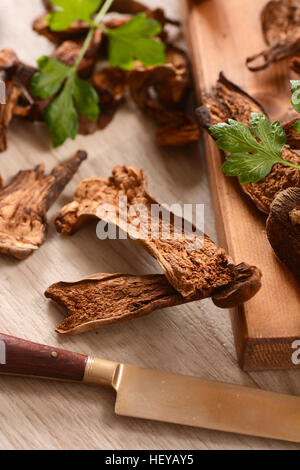 getrocknete Steinpilze auf Schneidbrett aus Holz Stockfoto