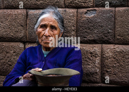 CUZCO, PERU - ca. NOVEMBER 2016: Eine unbekannte Frau betteln um Geld in einer der Straßen von Cuzco´s Stadtzentrum ca. 2016 Stockfoto