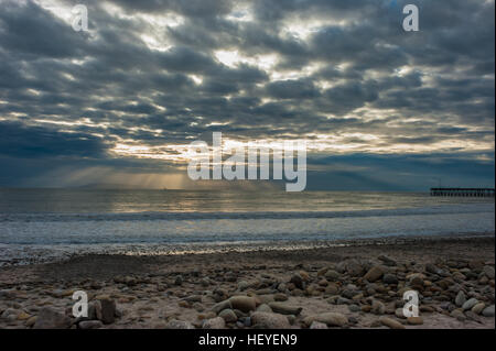 Sonnenstrahlen brechen durch die Regenwolken in der Abenddämmerung. Stockfoto