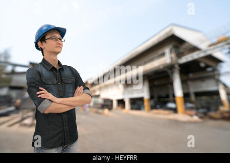 Asiatische Ingenieur oder Techniker, die auf der Suche nach oben, mit Beschneidungspfad, blur Fabrik Hintergrund, Industrie oder engineering-Konzept, jung und schön Stockfoto