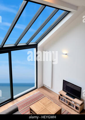 Modernes Wohnzimmer mit großen Fenstern und Blick auf Meer. Ansicht von oben Stockfoto