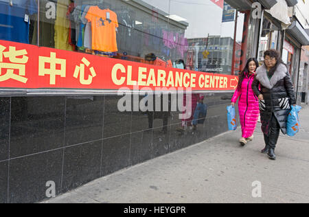 Zwei Amerikaner asiatischer Abstammung, vorbei an Modell Freigabe Center an der Roosevelt Avenue in Chinatown, Downtown Flushing, Queens, New York Stockfoto