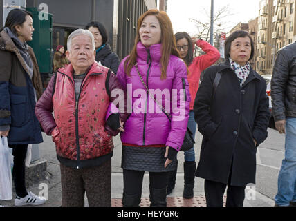 Asiatische Frauen gehen Arm in Arm auf der Main Street in Chinatown, Downtown Flushing, Queens New York Stockfoto