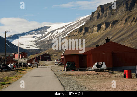 Europa, Norwegen, Svalbard (Spitzbergen), Longyearbyen, Hauptstraße mit typischen Gebäuden und Snow capped Berge hinter Stockfoto