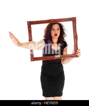 Eine böse Frau sucht Trog ein Bild Frame dehnen sich einerseits sagen, Nein, für weißen Hintergrund isoliert. Stockfoto