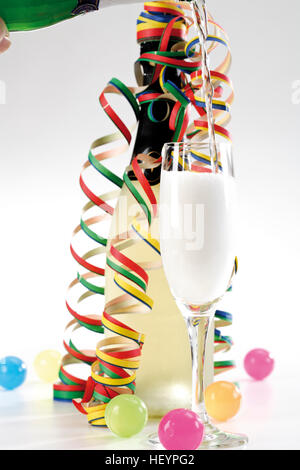 Champagner in ein Glas, Flasche Champagner und Luftschlangen gegossen Stockfoto