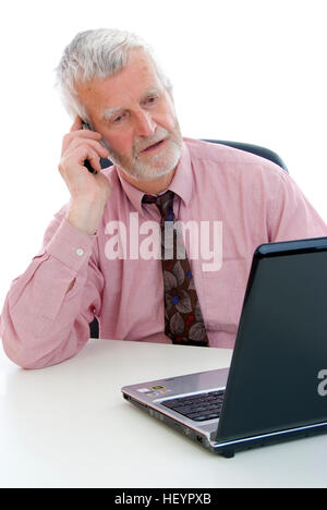 Älteren Geschäftsmann telefonieren mit Handy während der Arbeit am laptop Stockfoto