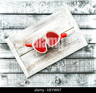 Herzförmige Schalen mit roter Tee trinken auf rustikalen hölzernen Hintergrund. Valentinstag-Konzept Stockfoto