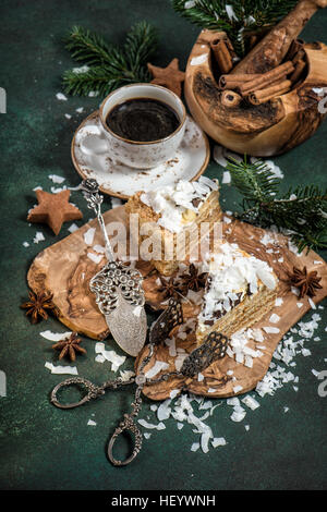 Honigkuchen mit Weihnachtsdekoration und Tasse Kaffee auf dunklem Hintergrund. Festliche süße Speisen. Vintage-Stil getönten Bild Stockfoto