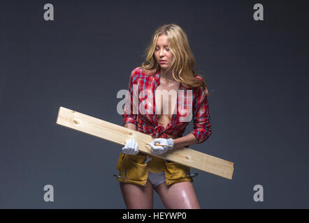 Hübsche Frau Bauarbeiter mit Werkzeug Gürtel und Seil in ihren Händen. Stockfoto