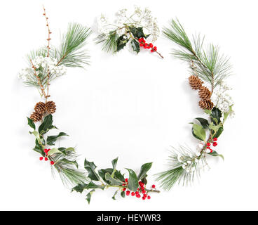Rahmen aus Kiefer Äste mit Ilex hinterlässt auf weißem Hintergrund. Weihnachten Blumen flach legen Stockfoto