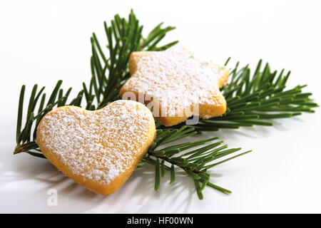 Herzförmig und sternförmige Spritzgebäck Weihnachten auf einen Tannenzweig, Weihnachtsdekoration Stockfoto