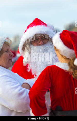 Weihnachtstag 25. Dezember 2016. White Christmas Dip in Boscombe, Bournemouth, Dorset, Großbritannien. Tapfere Freiwillige stürzen sich in das kalte, raue Meer zum Schwimmen, zum 9. Jährlichen Charity Christmas Morning Swim, gekleidet in ausgefallene Kleidung Kostüme und sammeln Geld für Macmillan Pflege vor Ort in Christchurch, eine Specialist Palliative Care Unit für Patienten in der lokalen Gemeinschaft. Hunderte nehmen an der Veranstaltung Teil, die für viele vor ihrem Mittagessen eine beliebte Tradition geworden ist. © Carolyn Jenkins/Alamy Live News Stockfoto
