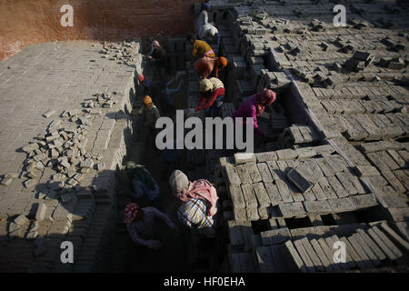 Bhaktapur, Nepal. 27. Dezember 2016. Wanderarbeitnehmer Stapeln rohen Ziegel in einer Ziegelei in Bhaktapur, Nepal auf Dienstag, 27. Dezember 2016 zu brennen. Nepalesischen und indischen saisonale Arbeiter kommen in der Wintersaison an Öfen arbeiten. © Skanda Gautam/ZUMA Draht/Alamy Live-Nachrichten Stockfoto