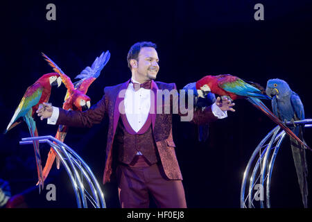 Tiertrainer Alessio führt während der Premiere des Circus Krone Winterprogramm in München, Deutschland, 25. Dezember 2016 mit Papageien. Foto: Tobias Hase/dpa Stockfoto