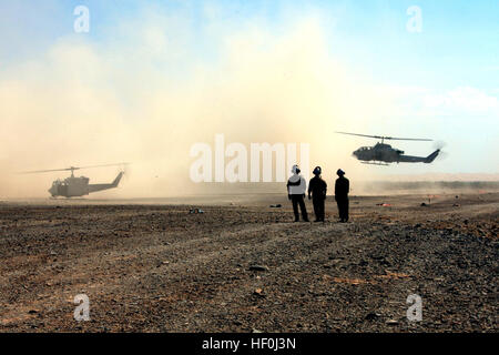 Marines mit MAG-49 sehen Sie eine UH-1N Huey und ein Bell AH-1 Super Cobra Land vorwärts Bewaffnung und Betankung Punkt außerhalb Marine Corps Air Station Yuma, Arizona, Juli 25. Bei der FARP Marines betankt und bewaffnet die Hubschrauber für Trainingsmissionen während Betrieb Javelin Schub 2011. Kampfmittel Marines arm Geschwader für den operativen Erfolg DVIDS437261 Stockfoto