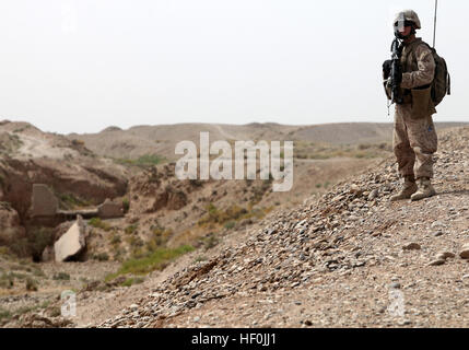 Dayton, Nevada, native Lance Cpl. Jackson Bergstrom, ein Feld-Funker mit Hauptsitz Batterie, 1. Bataillon, 12. Marine Regiment, sorgt für Sicherheit von einem Hügel während einer angehaltenen Patrouille.  Marines mit der Batterie müssen weiterhin im tiefsten Sommer, trotz Temperaturen regelmäßig über 110 Grad Fahrenheit in ihrem Bereich der Provinz Helmand patrouillieren. Marines schieben durch sengende Temps Sicherheitsleistung 110826-M-YI942-007 Stockfoto