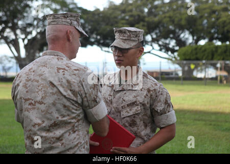 U.S. Marines CPL. Jason Kim (rechts), schüttelt Hände mit Oberst Brent Willson (links), Kommandeur, Sitz und Service Battalion, US Marine Corps Forces, Pazifik, während eine Förderung und Preisverleihung am Camp Smith, Hawaii, 3. Oktober 2011. Kim wurde zum Unteroffizier befördert. (U.S. Marine Corps Foto von Lance Cpl. Jerome Reed/freigegeben) Bataillon Aktion Oktober 2011 111004-M-PM709-021 Stockfoto