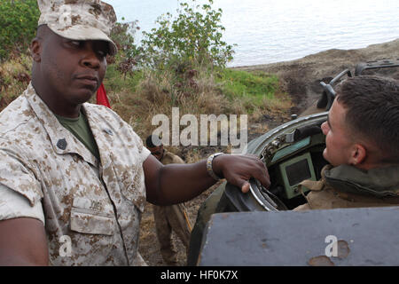 US Marine Gunnery Sgt. Anthony Jones, mit Combat Assault Unternehmen, 3rd Marine Regiment, motiviert Lance Cpl. Thomas Cunningham, Motor für eine amphibische Fahrzeug, Französisch Airborne Marines, vor dem Eintritt in das Wasser auf der Marine Corps Base Hawaii, Kaneohe Bay, 6. Oktober 2011. Combat Assault Firma Marines und Französisch Airborne Marines sind Teil der Übung AMERCAL 2011which ist ein Zug-Ebene zur Bekämpfung Arme kombiniert Austausch zwischen der französischen Streitkräfte, Neu-Kaledonien und USA Interoperabilität, Verbesserung der Beziehungen zwischen Militär und Militär und Verbesserung der gegenseitigen Kampffähigkeiten mit Fren Stockfoto