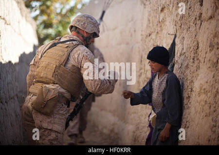 U.S. Marine Lance Cpl. Dominic Evola, eine 29 Jahre alte Schütze mit Zug springen, Sitz und Dienstleistungsunternehmen, 3. Bataillon, 3. Marine Regiment, von Medford, NJ, grüßt einen afghanischen junge von "stampfenden Fäuste" unterwegs zu einer lokalen Residenz für ein Asura hier, November 22. Nach ihrer jüngsten Übernahme von Verantwortung für die Sicherheit im Garmsir wechselte die Führung der "Amerikas Bataillon" Bezirk Gouverneur Mohammad Fahim zu besuchen und interagieren mit den Bürgern im ganzen Distrikt, 22. November bis 24. Während der Besuche Fahim und die Marines diskutierten Themen wie Stammes-Einheit, Bildung, insurgen Stockfoto