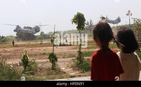 Thai Kinder beobachten, wie zwei CH-46E Sea Knight Hubschrauber mit Marine Medium Hubschrauber Geschwader 265 (REIN), 31. Marine Expeditionary Unit, vorbereiten, während eine non-Combatant Evakuierung Betrieb Übung, Februar 12 zu landen. Die Hubschrauber waren Bürger evakuieren, während ein mock NEO, die Marines und Segler aus bekämpfen Logistik-Bataillon-31 und Battalion Landing Team enthalten 1. Bataillon, 4. Marinen, 31. MEU sowie fünf teilnehmenden Nationen, während der Übung Cobra Gold 2012. Cobra Gold 2012 zeigt die Entschlossenheit der USA und der teilnehmenden Nationen um Interoperabilität zu erhöhen ein Stockfoto