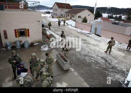 Georgische Soldaten aus Charlie Kompanie, 23. Light Infantry Battalion, wachsam zu bleiben, während patrouillieren in den Dorfstraßen und bieten Sicherheit für andere Mitglieder der Einheit während sie treffen sich mit lokalen Behörden und Dorfältesten während einer Mission Probe trainieren Sie im gemeinsamen multinationalen Readiness Center Hohenfels, Deutschland, Februar 20. Der 23. Infanterie-Bataillon georgischen Licht bereitet Aufstandsbekämpfung in Afghanistan als Teil von Georgien Deployment Program - International Security Assistance Force zu unterstützen. Marines beobachten GeorgianE28099s Charlie Kompanie 23. LIB raid feindlichen Aufständischen Stockfoto