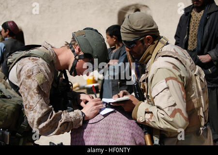 Britischen Royal Marine Commando Lance Cpl. Alan Cahill, links im Vordergrund, schreibt ein afghanischer Mann Informationen für die Bearbeitung neben eines afghanischen Task-Force-Soldaten im Kajaki, Provinz Helmand, Afghanistan, 1. März 2012. ATF-Soldaten und britischen Royal Marines teilgenommen an einer Patrouille auf der Suche nach Waffenlager und hochwertige Ziele. (Foto: U.S. Marine Corps CPL Andrew J. Good/freigegeben) Enduring Freedom 120301-M-DL630-040 Stockfoto