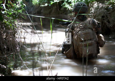 U.S. Navy Hospital Corpsman drittklassigen Shawn Borg mit Polizei Berater Team 3, Alpha Company, 1. Bataillon, 7. Marineregiment, Regimental Combat Team 6, geht in Deckung in einem Kanal nach das Team von feindlichen Kämpfern in Sangin, Provinz Helmand, Afghanistan 8. Mai 2012 beschäftigt war. Das Team erhielt direkten Handfeuerwaffen und zur Unterstützung während einer Patrouille in den Kanal geschoben. (Foto: U.S. Marine Corps Lance Cpl. Sean M. Searfus/freigegeben) 1-7 Patrouillen Sangin 120512-M-VH365-039 Stockfoto