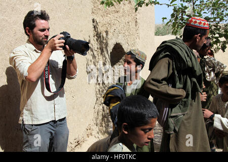 Ben Foley, links, Kameramann, mit Nachrichtensender Al Jazeera Englisch Fotografien lokale afghanische Kinder in einer Schule in Kajaki, Provinz Helmand, Afghanistan 23. Mai 2012. Foley berichtete über Koalitionstruppen, die Verantwortung für Sicherheit in der Region an afghanischen nationalen Sicherheitskräfte zu übertragen. (Foto: U.S. Marine Corps CPL Andrew J. Good/freigegeben) Nachrichtensender Al Jazeera Besuch Kajaki 120523-M-DL630-033 Stockfoto