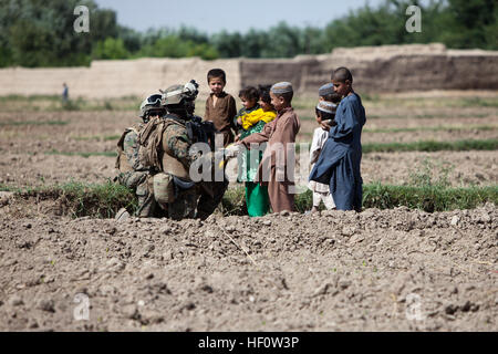 US Marine Corps 1st Sgt Donald Young, vorne links, Firma First Sergeant mit Delta Company, 1. Bataillon, 7. Marineregiment Regimental Combat Team 6, schüttelt einen lokalen afghanischen jungen Hand während einer Patrouille in Sangin, Provinz Helmand, Afghanistan 4. Juni 2012. Marines interagiert mit der örtlichen Bevölkerung Beziehung aufbauen und Änderungen in der lokalen Atmosphären zu beobachten. (US Marine Corps Foto von Pfc. Jason Morrison/freigegeben) patrouillieren 1-7 Marines in Sangin 120604-M-TH715-055 Stockfoto