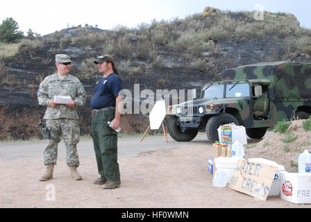 Colorado Army National Guard Spc. Daniel Evanson, Augmentee mit der 193. Military Police Battalion, blickt auf eine aktualisierte Feuer Plan mit Mark De Gregorio, National Park Service, der auch auf Abruf für Feuerunterstützung mit verschiedenen Incident-Management-Teams von Verkehr Kontrollpunkt 5, Eingang zum Rist Canyon in der Nähe von Fort Collins, Colorado, einem großen Feuer Perimeter Access Point, Juni , 15, 2012.  Der Colorado National Guard unterstützt die Larimer Land Sheriff Office mit Evakuierung und zum Schutz von Personal und Unterkunft während des Brandes High Park. "Es ist sehr beruhigend zu Menschen gerecht zu werden Stockfoto