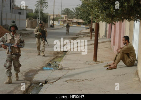 AR-RAMADI-Irak (27. Juni 2005) – Lance Cpl. Benjamin L. Griffith, ein MG-Schütze und Ausbilder mit kombinieren Aktion Platoon, Unternehmen B, 1. Bataillon, 5. Marineregiment, ein Mitglied der irakischen Sicherheitskräfte patrouillieren zusammen während einer Mission in der Stadt hier Straße 26 Juni mit Firma C Marines. Griffith, ein 21-jährige aus Cassoday, Kansas, führt neu ausgebildeten Mitglieder des ISF auf Missionen in der Stadt, ihre militärischen Fähigkeiten zu verbessern. Die 2002 Flint Hill High School Absolvent führt tägliche Missionen in der Stadt mit seinen Amtskollegen ISF. Griffith und acht ISF begleiten Trupps mit Stockfoto