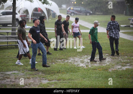 Eine Gruppe von Marines und Segler mit 2. Marine Logistics Group tanzen im Regen während einer Kaserne Bash an Bord Camp Lejeune, North Carolina, 22. August 2012. Die Veranstaltung begann in den frühen Nachmittag mit einem Flag-Fußball-Turnier.  Nach dem Turnier genossen Servicemembers federnd Häuser, Klettern, Sumo-ringen, Tauziehen und einer Hypnose-Show.  Die Teilnehmer hatten auch die Möglichkeit, Tickets für Verlosungen, Geschenkkarten, einen TV, einen DVD-Player und zwei Fahrräder während der gesamten Veranstaltung zu gewinnen. 2. marine Logistics Group Befehl Gastgeber Kaserne Bash für einzelne Truppen 120822-M-HA146-024 Stockfoto