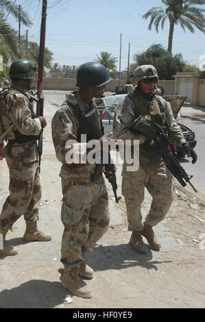 AR RAMADI, Irak (31. Juli 2005) – Corporal Grant R. Birtcher, ein Schütze mit kombinieren Aktion Platoon, Unternehmen B, 1. Bataillon, 5. Marineregiment und zwei Mitglieder der irakischen Sicherheitskräfte Patrouille eine Straße in der Stadt hier während einer Mission 31 Juli. Birtcher, ein 20-Year-Old halbe Navajo-Indianer aus Window Rock, ARIZ., führt die neu ausgebildeten Mitglieder des ISF auf Missionen in der Stadt, ihre militärischen Fähigkeiten zu verbessern. Die 2002 Fenster Rock High School Absolvent führt tägliche Missionen in der Stadt mit seinen Amtskollegen ISF. Birtcher und zwischen 12 und 24 ISF begleiten Marines mit 1. Batta Stockfoto