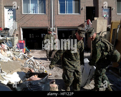 Mayetta, Kansas native, Lance Cpl. Cole Hasty (links), ein Funker und Norton, Ohio stammende Lance Cpl. Thomas Gibson (rechts), ein Spezialist der Einschiffung ziehen einen Müllsack voller Trümmer von einem ortsansässigen Garage in Staten Island, N.Y., 4 Nov.. Hasty & Gibson entstammen bekämpfen Logistik-Bataillon 26, mit dem 26. Marine Expeditionary Unit. Die Marines unterstützt lokale Katastrophe Hilfsorganisationen mit Aufräumarbeiten. Der 26. MEU ist in der Lage, Generatoren, Kraftstoff, sauberem Wasser und Hubschrauber heben Fähigkeiten um Katastrophenhilfe zu unterstützen. Die 26. MEU führt derzeit Pre-d Stockfoto